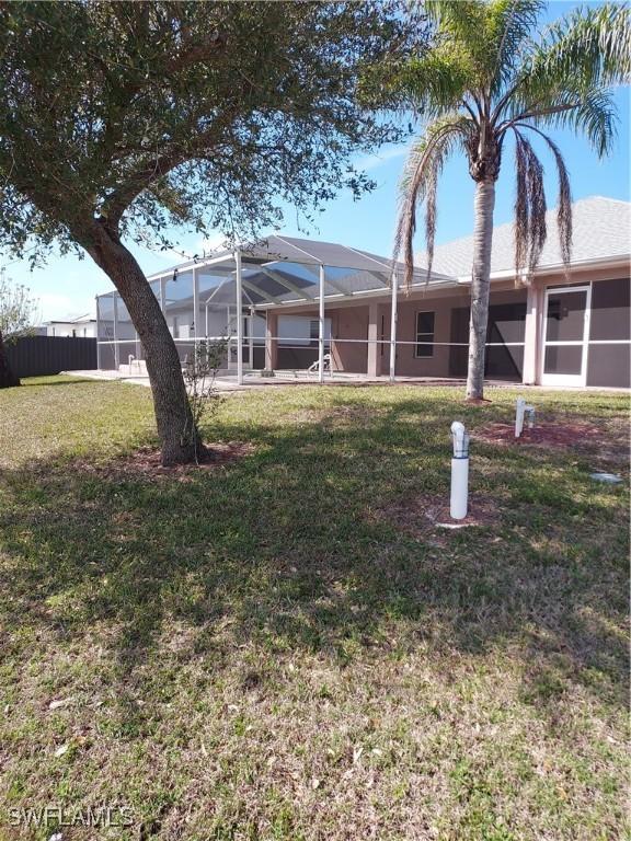 view of front of home featuring a front yard and glass enclosure