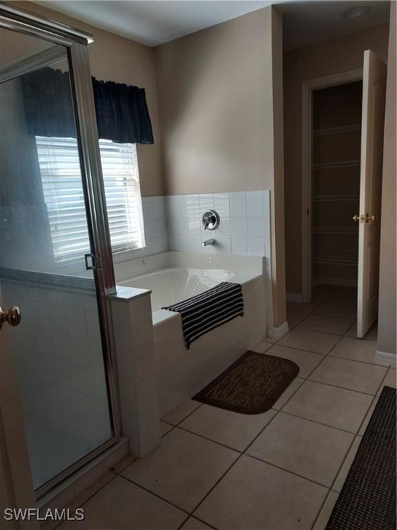 bathroom featuring tile patterned floors and shower with separate bathtub