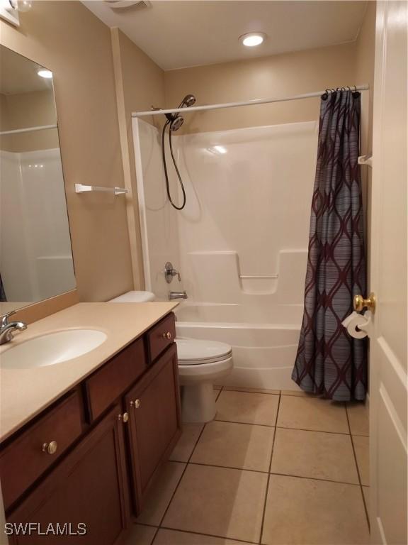 full bathroom featuring vanity, shower / bath combo, tile patterned floors, and toilet