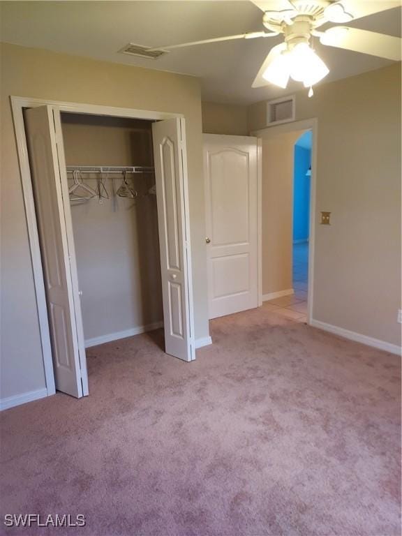 unfurnished bedroom featuring light colored carpet, a closet, and ceiling fan