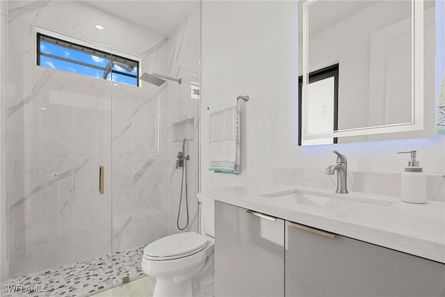 bathroom with a shower with door, toilet, and vanity