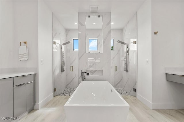 bathroom featuring separate shower and tub, hardwood / wood-style flooring, and vanity