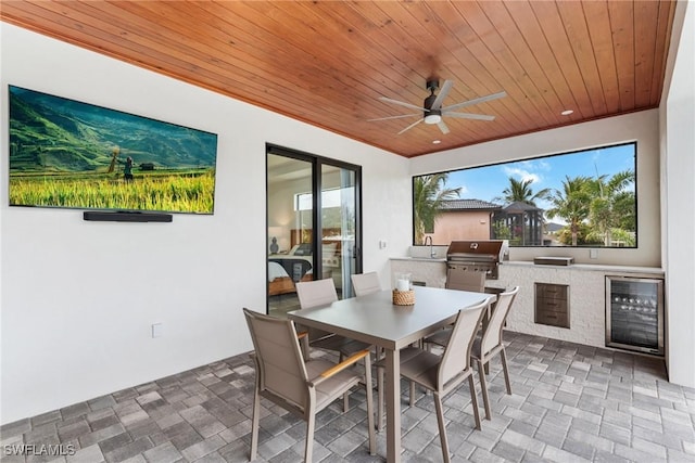 view of patio with ceiling fan, a grill, beverage cooler, and area for grilling