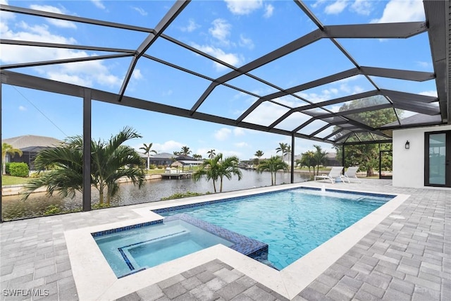 view of pool featuring glass enclosure, an in ground hot tub, a patio area, and a water view