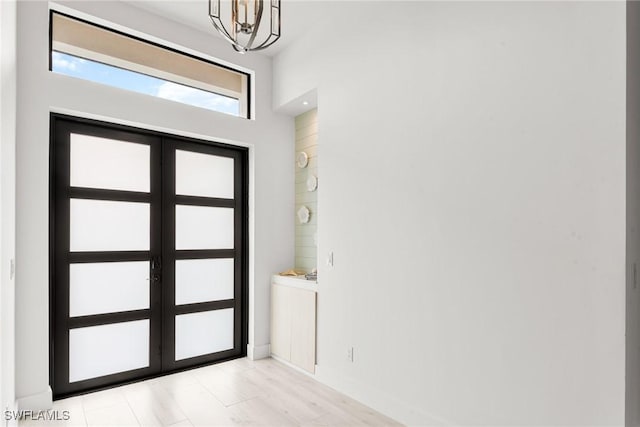 foyer entrance with a notable chandelier and french doors