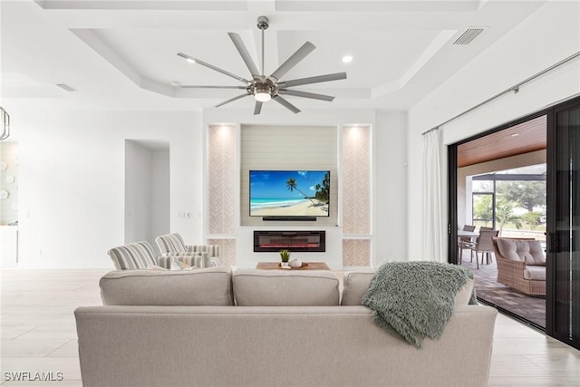 living room featuring a tray ceiling and ceiling fan