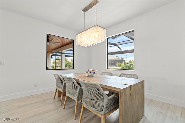 dining room with light hardwood / wood-style flooring and a chandelier