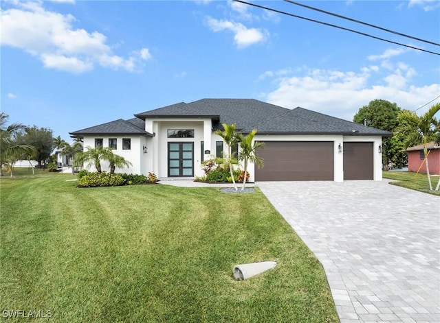 prairie-style home with a garage and a front lawn