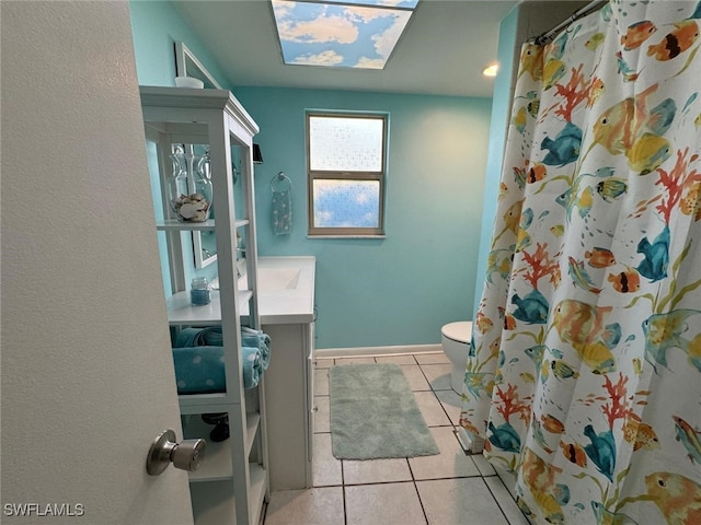 bathroom with tile patterned floors, toilet, a skylight, vanity, and a shower with shower curtain