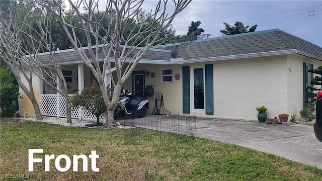 rear view of property featuring a lawn and a carport