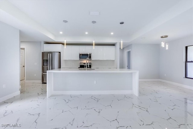 kitchen featuring a center island with sink, sink, hanging light fixtures, appliances with stainless steel finishes, and white cabinets