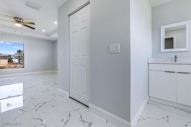 corridor featuring sink and a raised ceiling