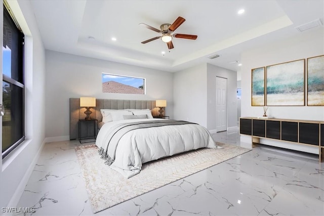 bedroom featuring ceiling fan, a closet, and a tray ceiling