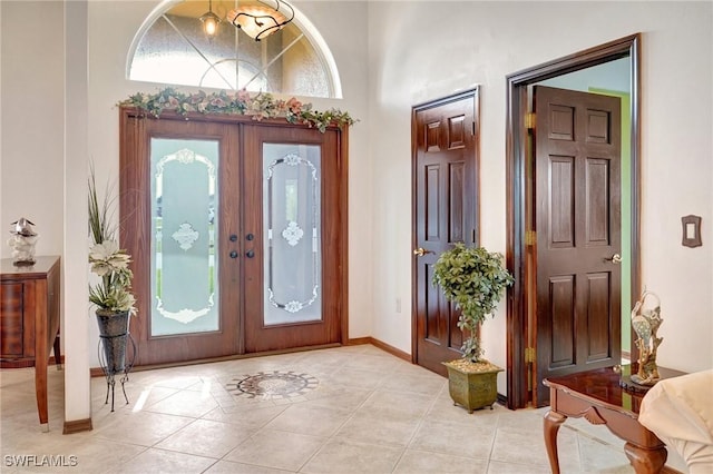 tiled foyer with a high ceiling and french doors