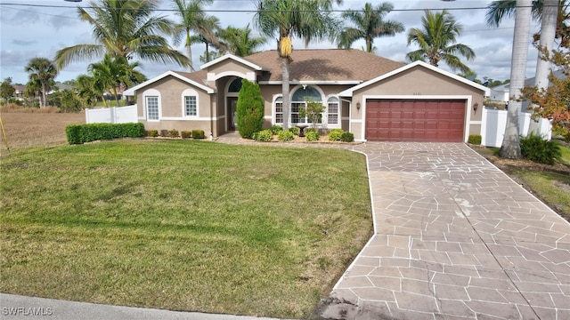 single story home featuring a garage and a front lawn