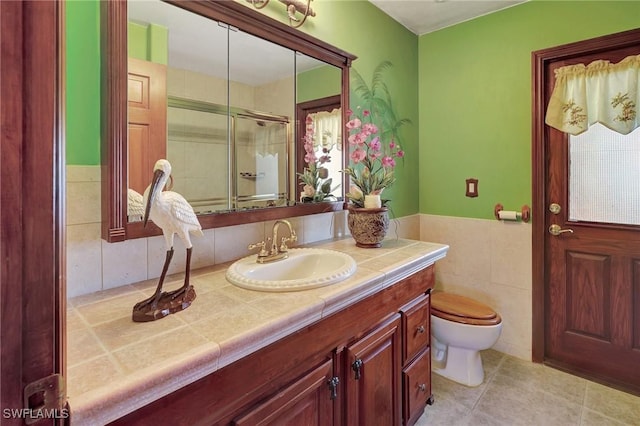 bathroom featuring vanity, tile walls, an enclosed shower, and toilet