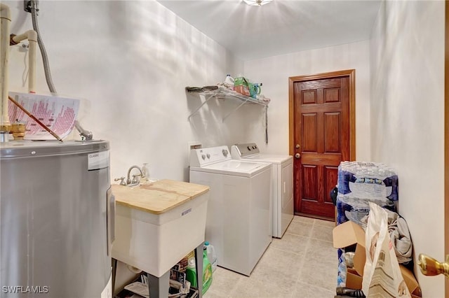 laundry room with electric water heater, sink, and independent washer and dryer