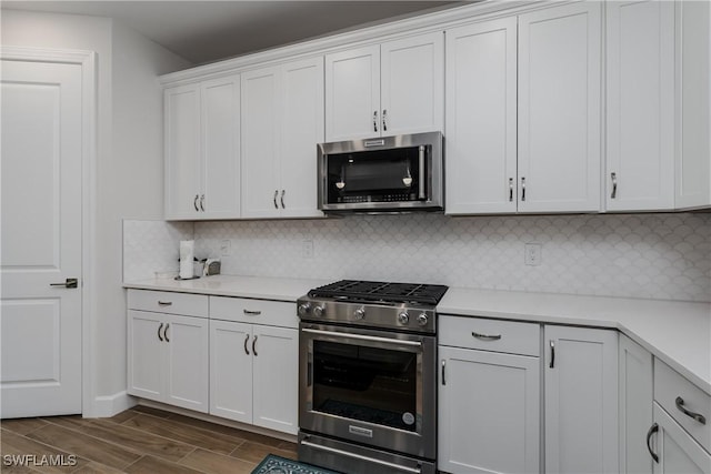 kitchen featuring decorative backsplash, white cabinetry, and appliances with stainless steel finishes