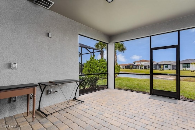 unfurnished sunroom with a water view