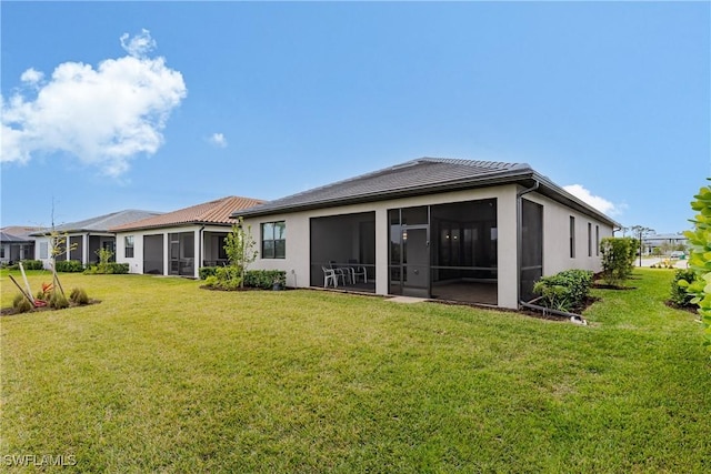 rear view of property featuring a sunroom and a lawn