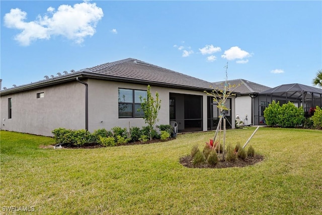 back of house featuring a lanai and a lawn