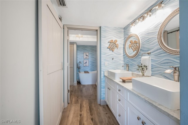 bathroom featuring vanity, hardwood / wood-style floors, and a washtub