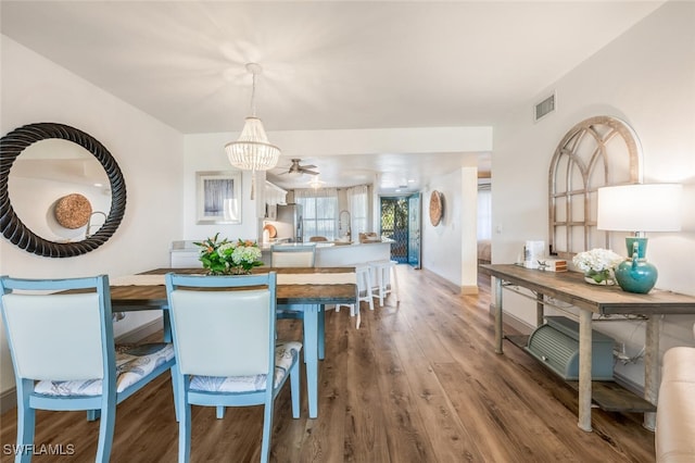 dining room with hardwood / wood-style floors and an inviting chandelier