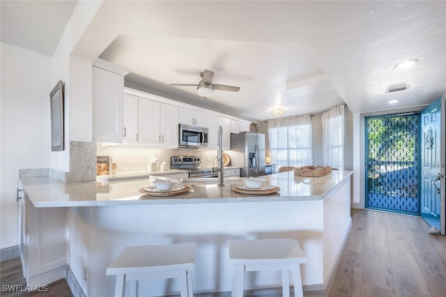 kitchen featuring a breakfast bar, stainless steel appliances, and kitchen peninsula