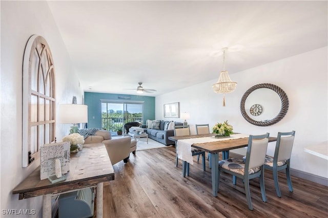 dining space featuring ceiling fan with notable chandelier and hardwood / wood-style floors