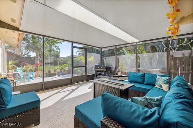 sunroom / solarium featuring an outdoor living space with a fire pit