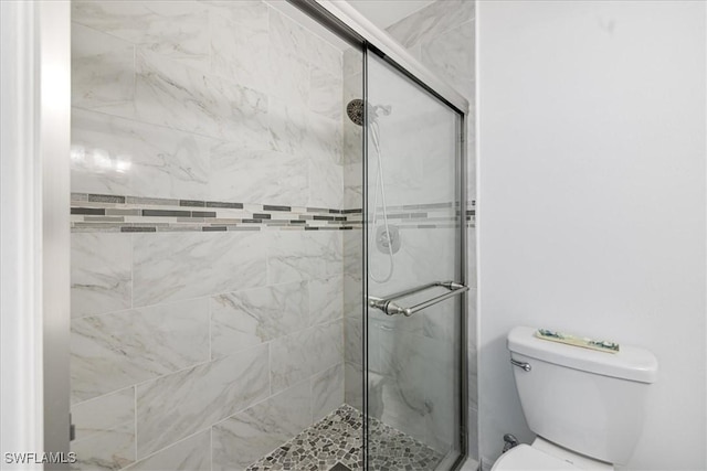 bathroom featuring a shower stall and toilet