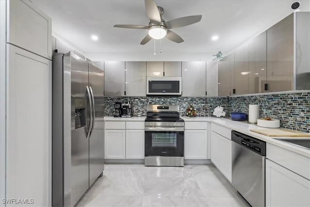 kitchen featuring tasteful backsplash, appliances with stainless steel finishes, light countertops, a ceiling fan, and marble finish floor