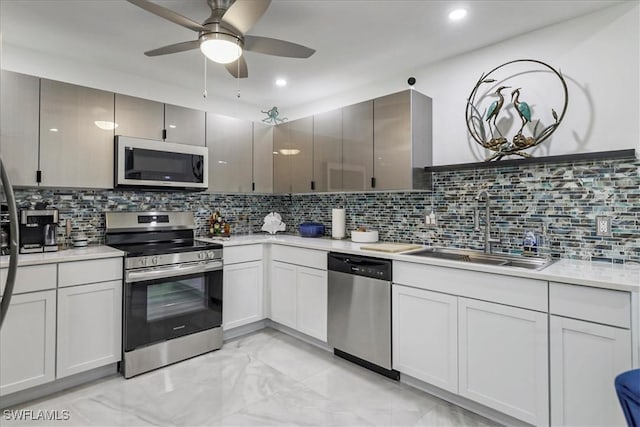 17310 Timber Oak Ln, Fort Myers, FL 33908 - kitchen with stainless steel appliances, a sink, a ceiling fan, light countertops, and tasteful backsplash
