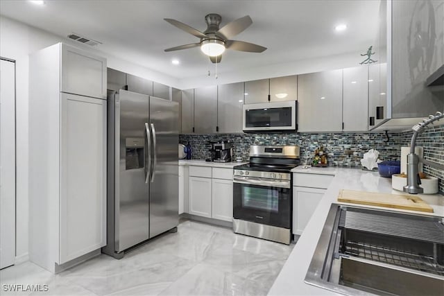 kitchen featuring ceiling fan, tasteful backsplash, visible vents, light countertops, and appliances with stainless steel finishes