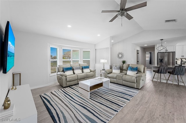 living room featuring lofted ceiling, ceiling fan, and light hardwood / wood-style floors