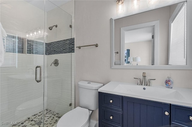 bathroom with toilet, vanity, and an enclosed shower