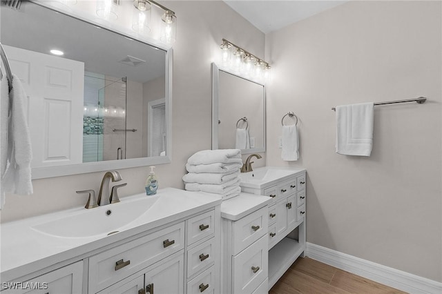 bathroom featuring hardwood / wood-style flooring, a shower with door, and vanity