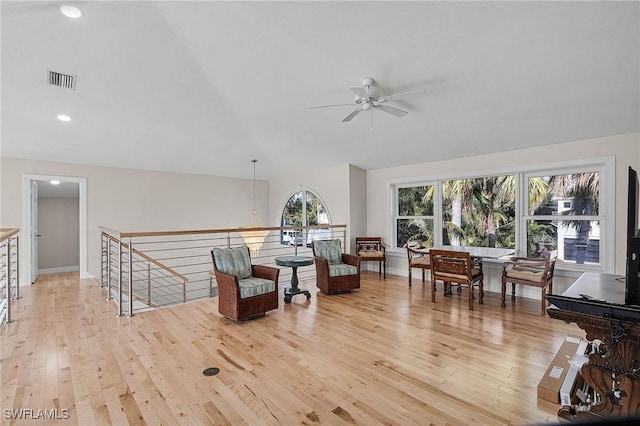 living area featuring light hardwood / wood-style floors, lofted ceiling, and ceiling fan