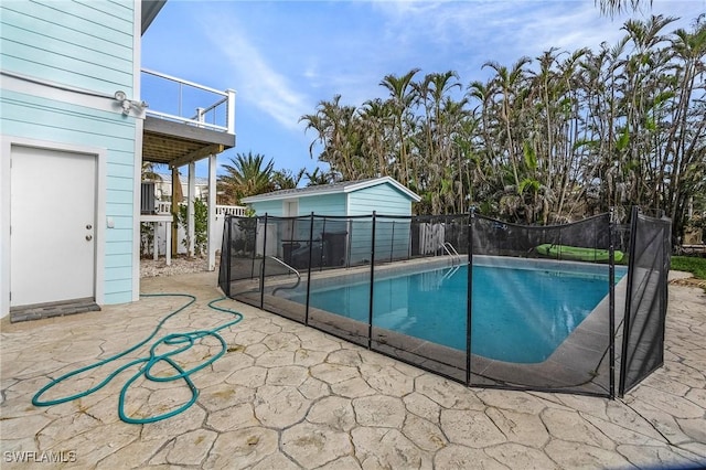 view of pool with an outbuilding and a patio