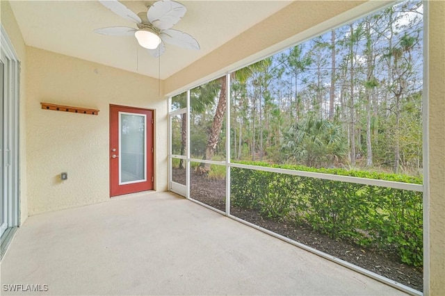 unfurnished sunroom featuring ceiling fan