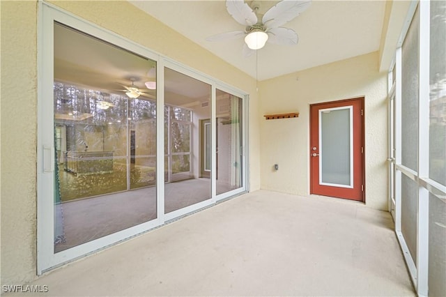 unfurnished sunroom with ceiling fan