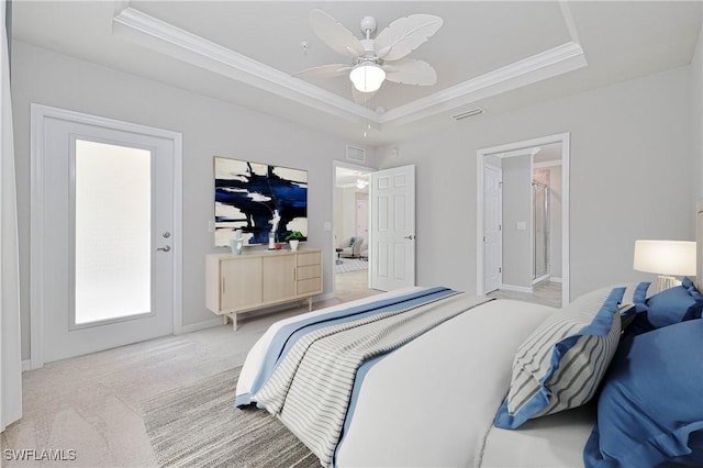 bedroom featuring ceiling fan, a tray ceiling, ornamental molding, and light carpet