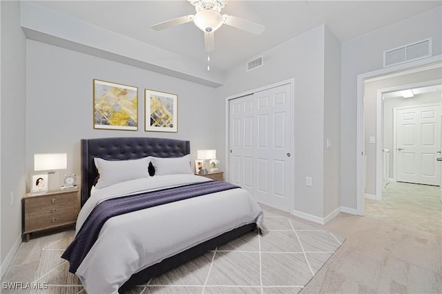 bedroom featuring ceiling fan, a closet, and light colored carpet