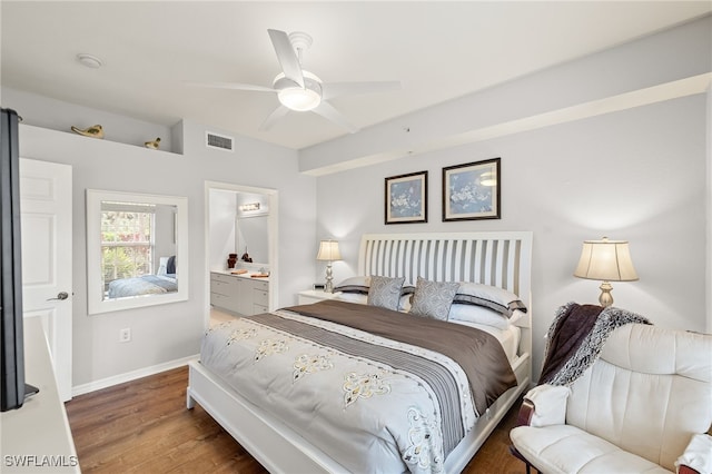 bedroom featuring ceiling fan, ensuite bathroom, and dark hardwood / wood-style floors