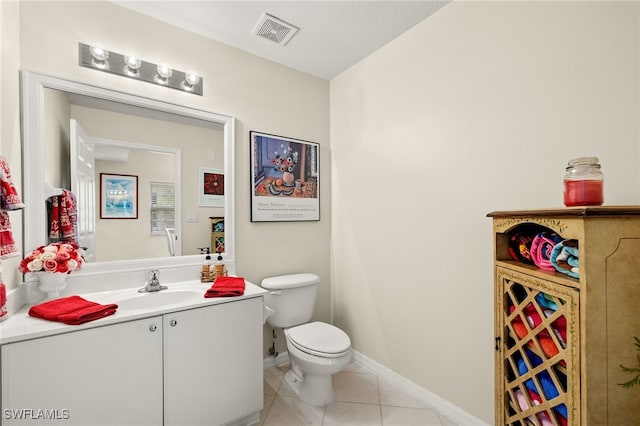 bathroom with toilet, vanity, and tile patterned floors