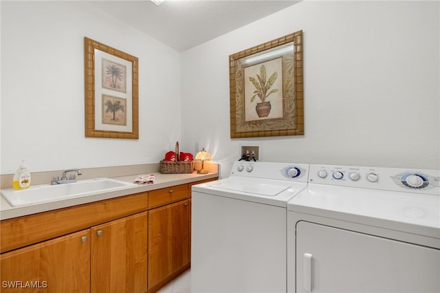 washroom with cabinets, sink, and washer and clothes dryer