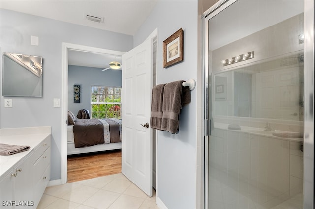 bathroom featuring ceiling fan, walk in shower, vanity, and tile patterned flooring