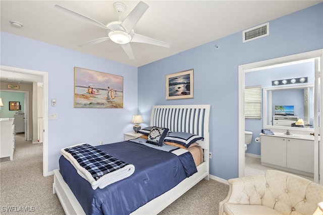 carpeted bedroom with ceiling fan and ensuite bathroom