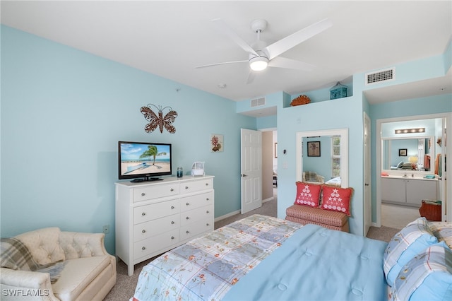 bedroom featuring ceiling fan, light colored carpet, and connected bathroom