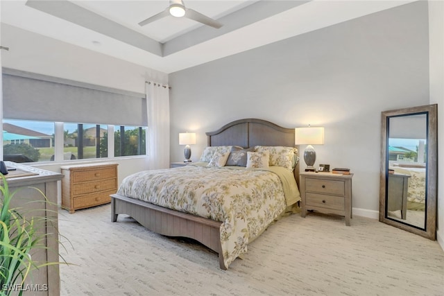 bedroom with ceiling fan and a tray ceiling